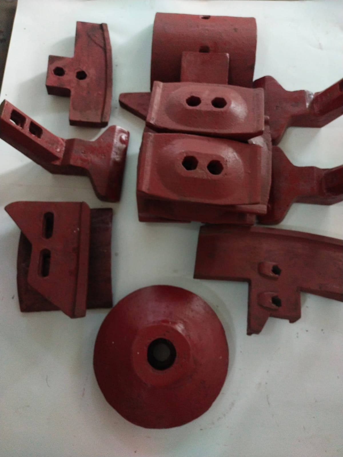 Set of cast metal industrial components in red primer