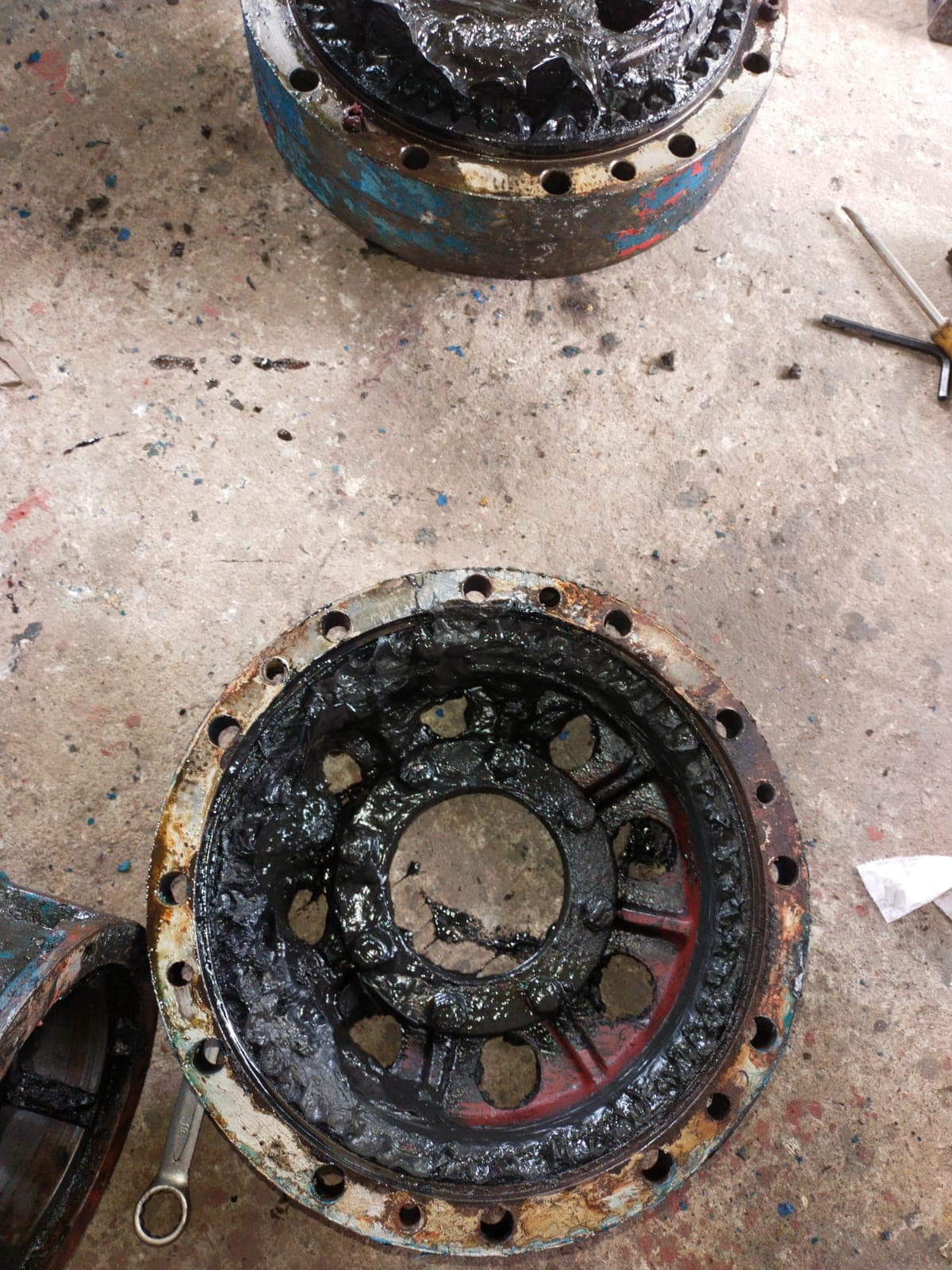 Planetary gear hub being serviced with grease and tools