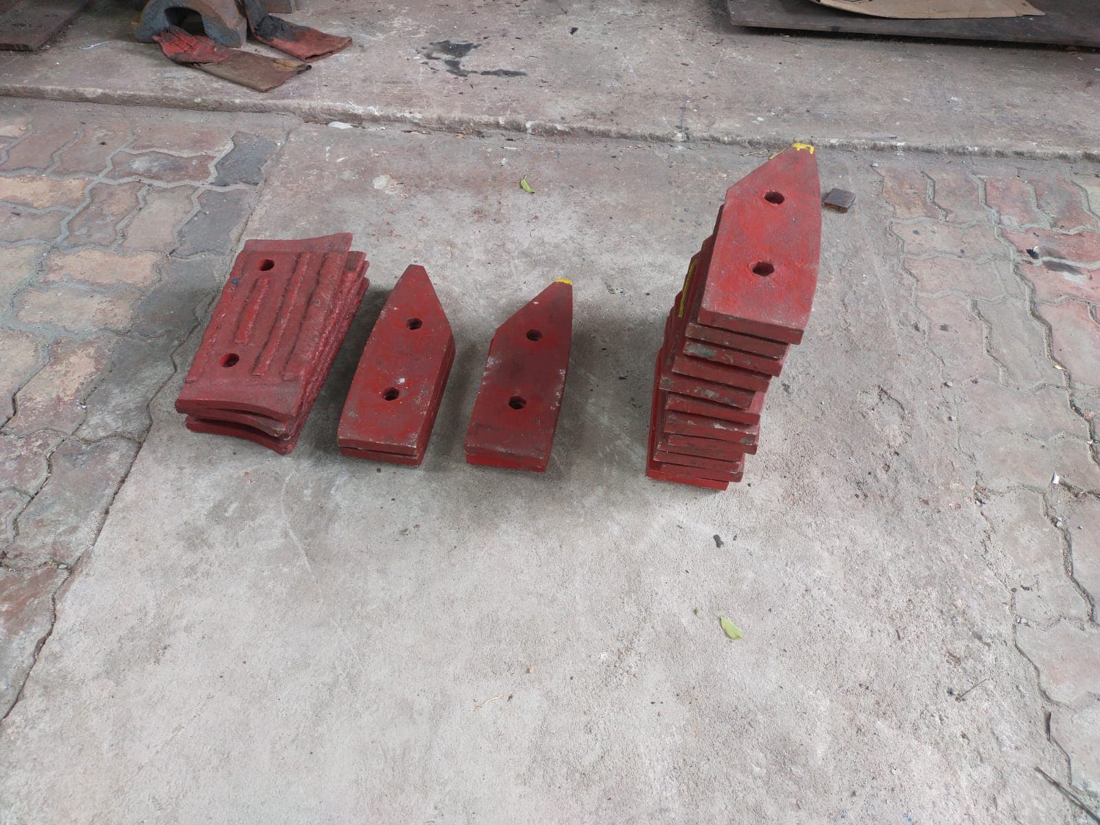 Stacks of red-painted wear plates and wedge-shaped liner segments